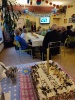 Seniorzy siedzą przy stołach słuchając życzeń z okazji jubileuszu Klubu Seniora Niezapominajka